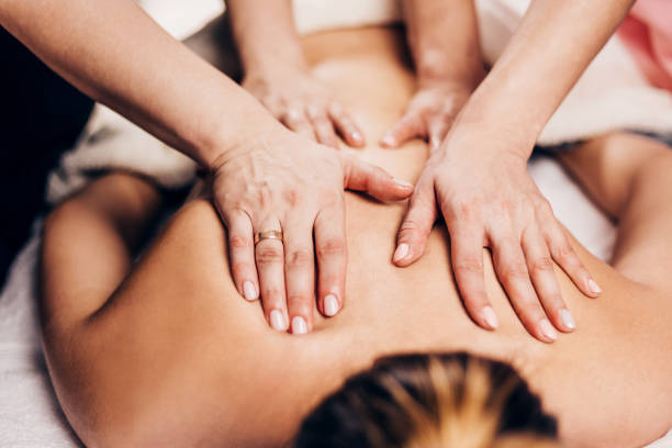 4 hands massage - two masseurs work simultaneously on the patient back - effective therapeutic massage